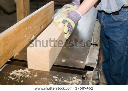 A carpenter(sawman)  works on woodworking the machine tool.