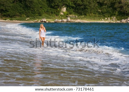 A young woman goes on sea beach.