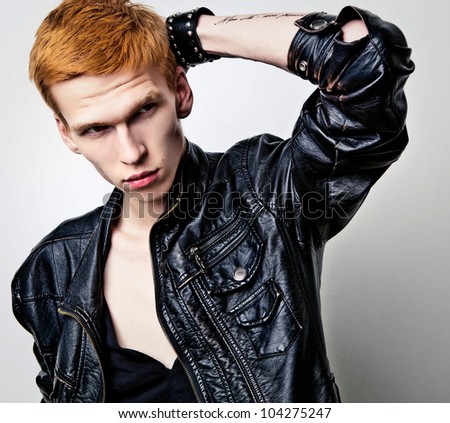 Young red haired man on light background.