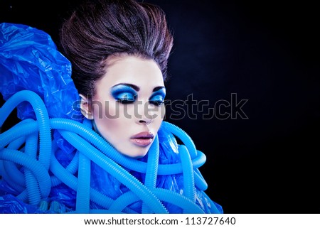 Futuristic beautiful young female face with blue fashion make-up.
