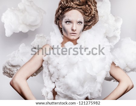 Romantic beauty with magnificent hair wandering in clouds. Studio fashion portrait.