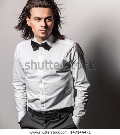 Portrait of handsome long-haired stylish man with bow tie.