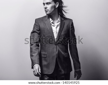 Elegant young handsome long-haired man. Black-white fashion portrait. Elegant young handsome long-haired man. Studio fashion portrait.