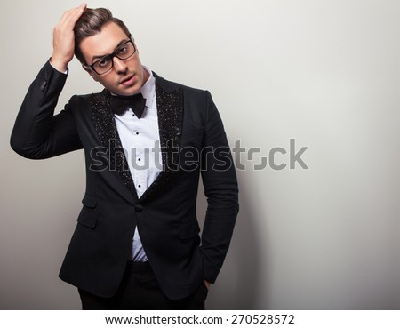 Elegant young handsome man in black luxury costume. Studio fashion portrait.