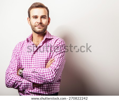 Elegant young handsome man in bright colorful shirt. Studio fashion portrait.