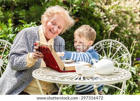 Positive grandmother and grandson spent time together in summer solar garden.