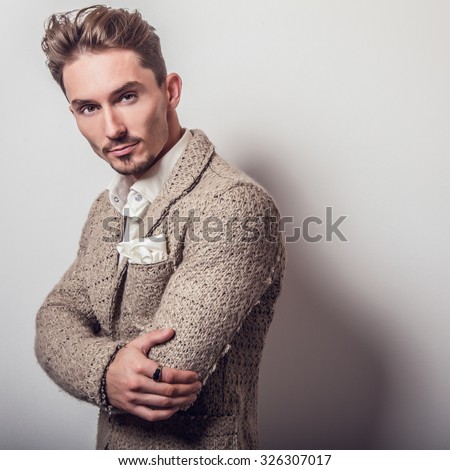 Elegant young handsome man in stylish beige costume. Studio fashion portrait.
