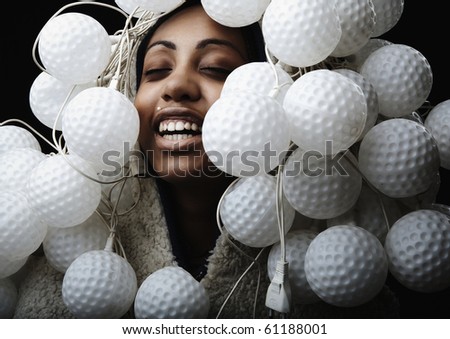Portrait of African woman covered with fixtures in form of ball for a golf