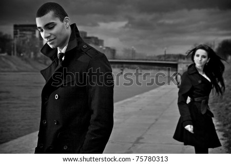 Beautiful stylish pair of young people outdoor going in different directions. Close-up men face.