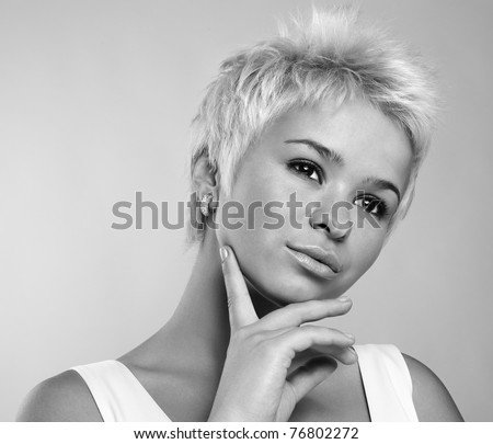Portrait of an attractive teenage girl posing against white background. Black-white photo.