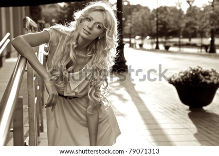 Beautiful blond model outdoor. Street fashion Sepia photo.