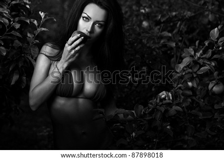 Sexual beauty dressed bikini poses in an autumn garden of apples. Black-white photo.