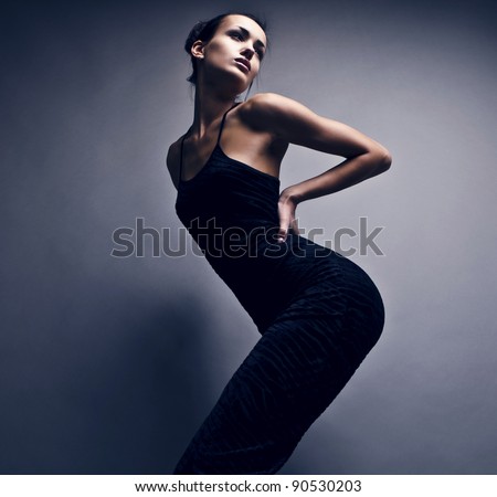 Beautiful woman on black classical dress pose in studio. Vogue style photo.