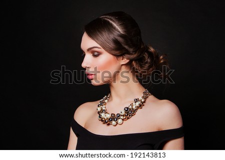 beautiful brunette with perfect evening makeup wearing jewelry