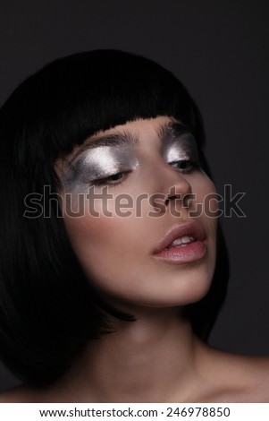 Beautiful young model with shining silver face makeup