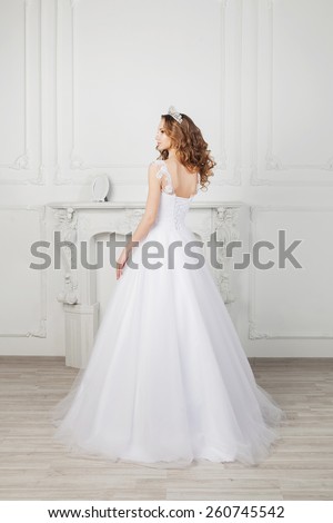 Back view of bride with long curly hair wearing luxurious wedding dress