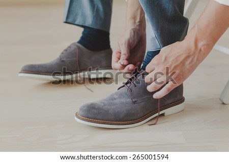 groom putting his wedding shoes. Hands of wedding groom getting ready