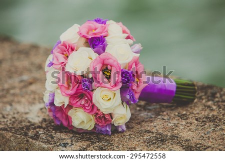 Brides bouquet with purple, pink and white flowers on wedding day