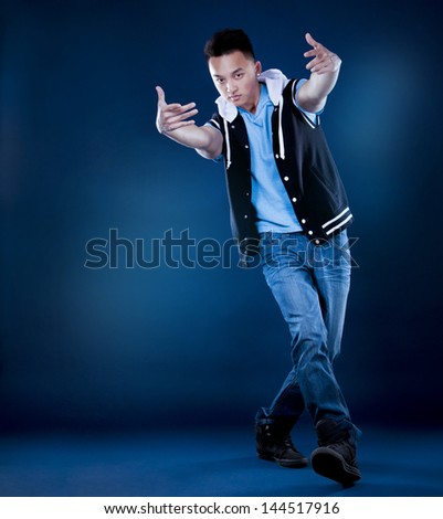 chinese breakdancer posing on dark background