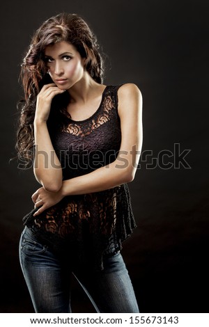 fashion model brunette wearing black outfit on black background