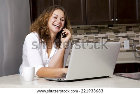 woman drinking coffee while chatting on the phone, using laptop