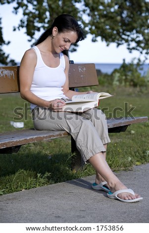 beautiful brunette sitting down reading book