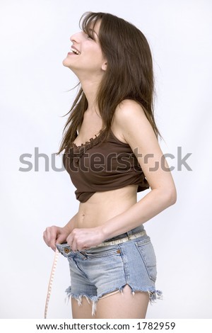 woman measuring her waist wearing jeans shorts
