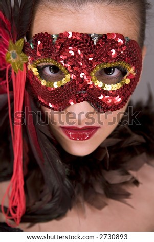 mysterious brunette wearing carnival red mask on her face