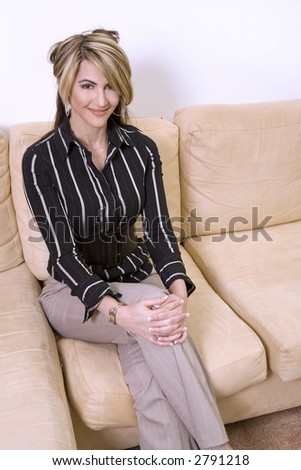 beautiful woman sitting on the sofa in living room wearing businesss wear