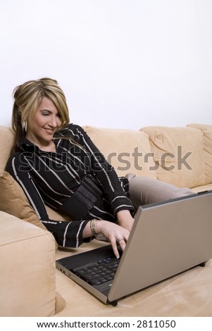 beautiful woman sitting on the sofa in living room wearing businesss wear and using her computer