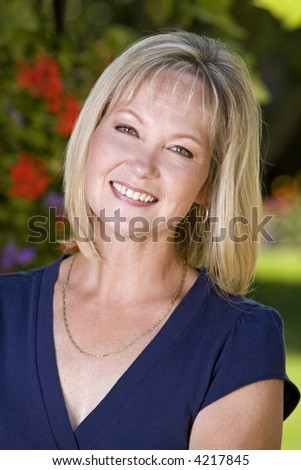 beautiful older blond woman with a happy face in the summer