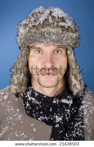russian man wearing fur with snow on blue