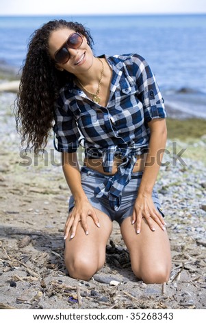 pretty brunette wearing summer outfit on the beach