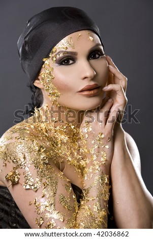 pretty brunette wearing gold outfit and matching makeup