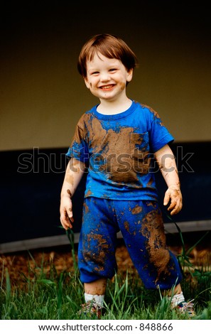Smiling boy after playing in mud