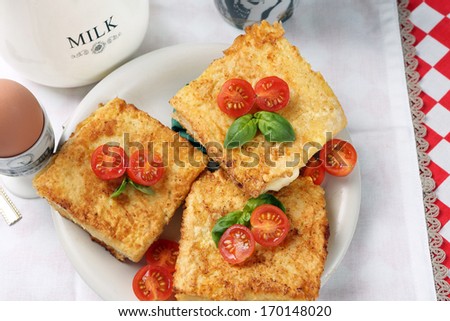 Toast with cheese and tomatoes, served with fried egg and a cup of milk