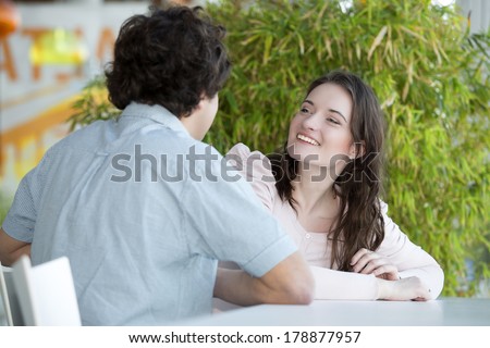 Love couple in shopping center sitting at the table and laughs