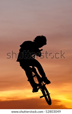 Silhouette of the boy playing Bicycle Stunts