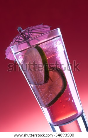 Cool, fresh, red cocktail with lime on a red background