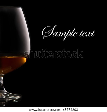 Glass of brandy over black background and space for your own text on right
