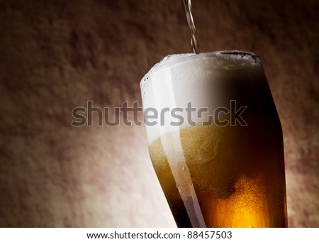 Beer into glass on a old stone