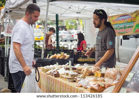 NEW YORK CITY - AUG 5: Man sells baked goods at Tompkins Square Park Greenmarket in New York City on Aug. 5, 2012. This farmers market is one of many bringing local food and produce to  NYC.