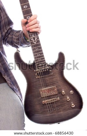 A guy holding his guitar by the neck against bright background