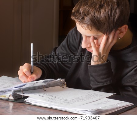 A Handsome Teenage Boy With A Notebook And Pen, Struggling With School ...