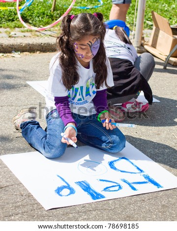 NEW YORK CITY - June 5:  An unidentified young participant of the Liver Life Walk makes a poster on Sunday, June 5, 2011 in Battery Park, New York City, NY.  The 3 mile walk is held by American Liver Foundation to fight liver disease.