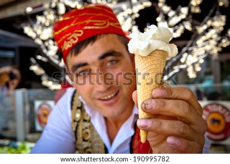 ISTANBUL - MAY 17 - Popular Turkish ice-cream vendor hands over a cone of ice-cream after performing playful tricks on May 17, 2011 in Istanbul.