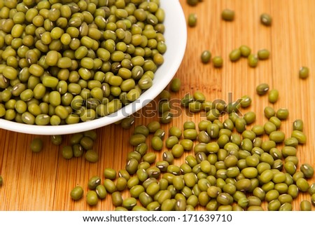 Mung beans in white bowl on wooden table