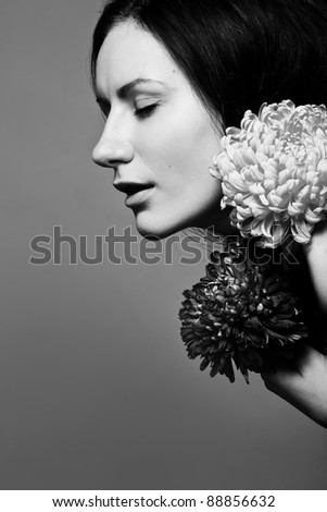 Sensual beautiful woman with flowers and closed eyes in black and white art photo