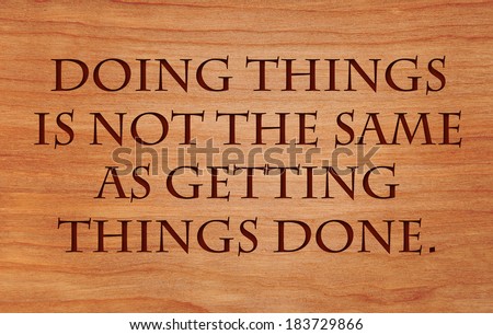 Doing things is not the same as getting things done - on wooden red oak background