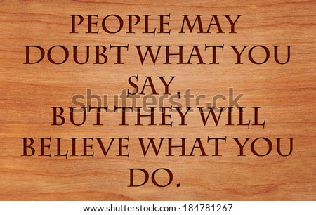 People may doubt what you say, but they will believe what you do - motivational quote by Lewis Cass on wooden red oak background